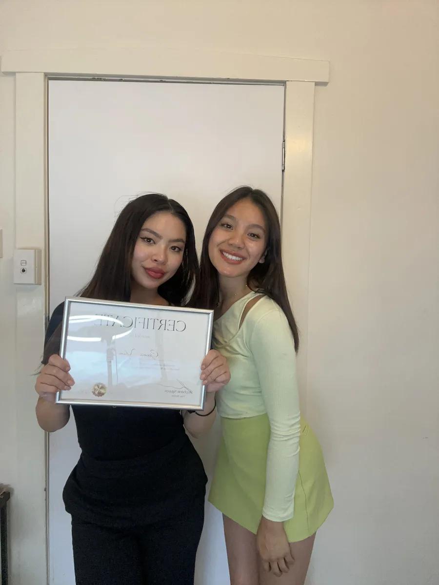 Two graduates with certificates
