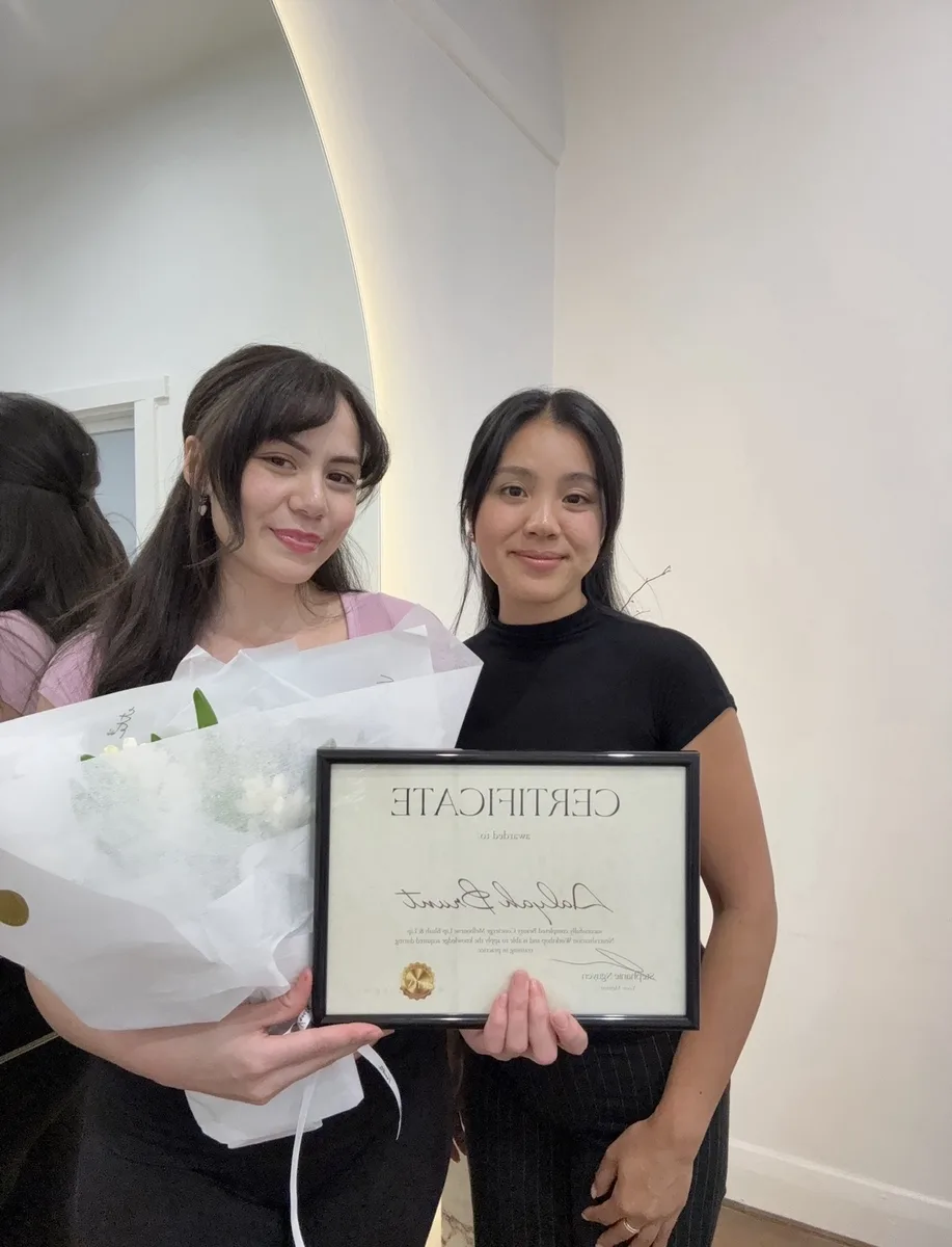 A graduate with flowers and her framed certificate