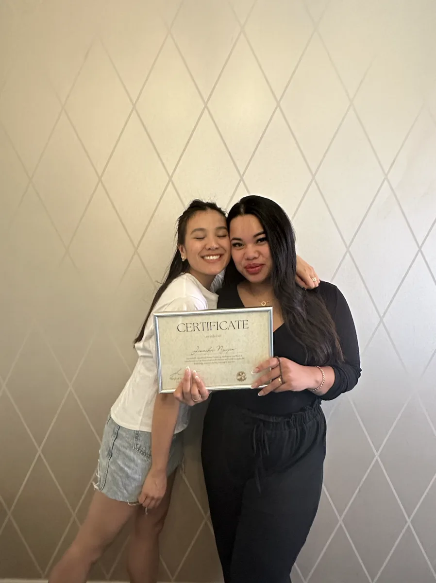 A graduate with Stephanie holding her certificate
