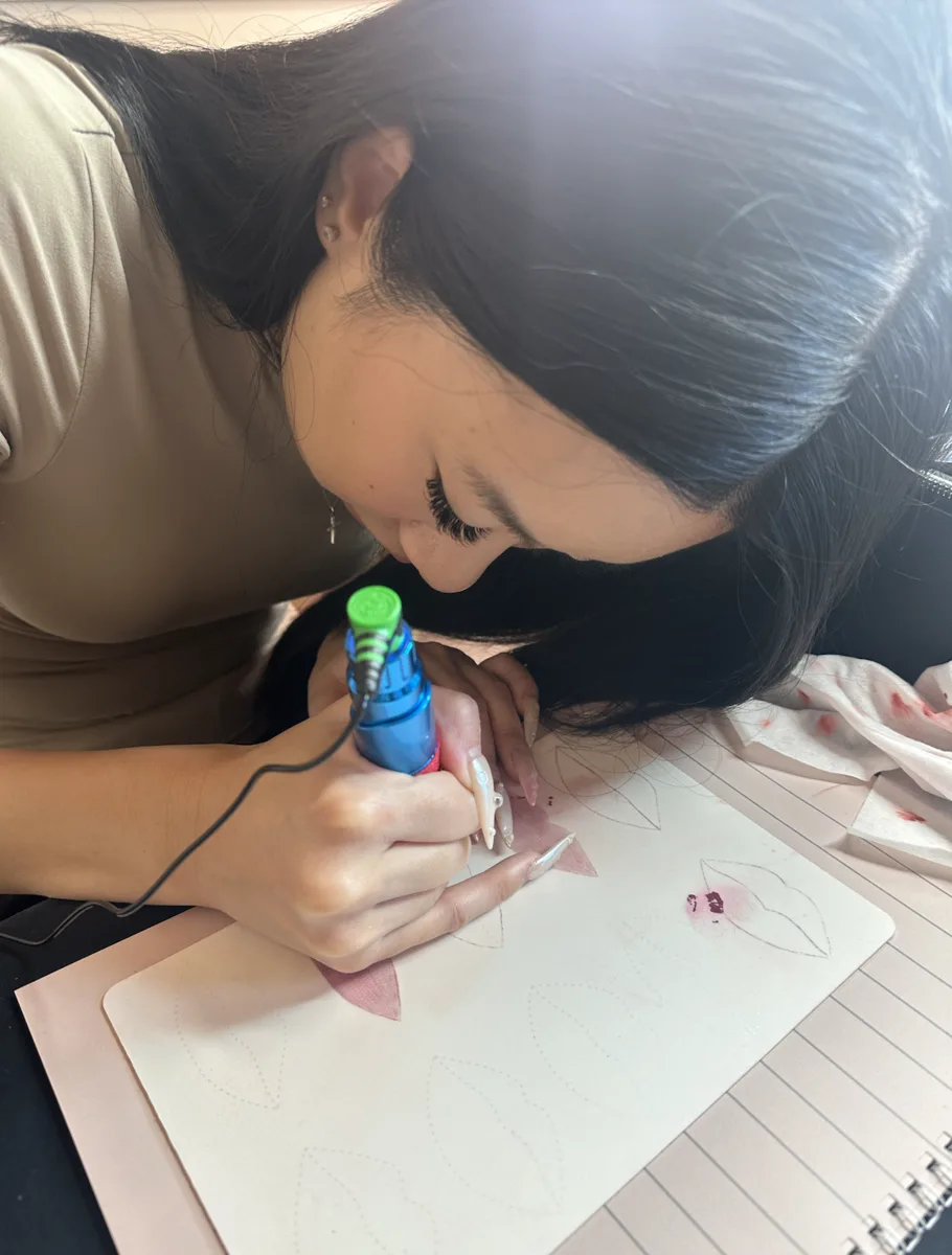 A student working through the lip colour theory manual during the beginners course